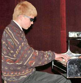 Mokinys groja pianinu